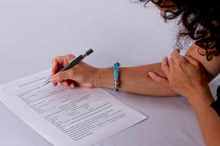 Image of woman hand with pen signing contract at workplaceの写真素材