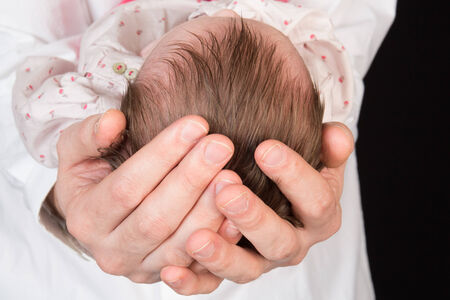 Newborn baby sleeping on the hands of his father