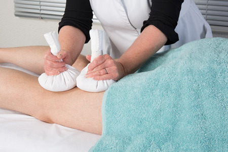 Man having Ayurveda massage with herbal ball.の写真素材