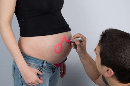 Symbol of a child girl writing on pregnant motherの写真素材