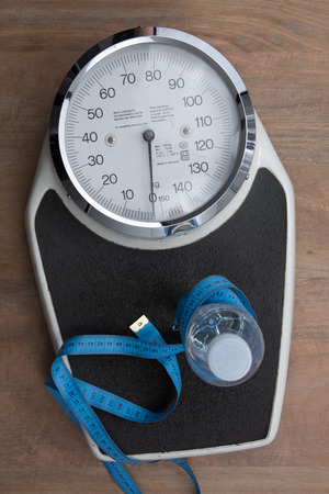 In a bathroom a scale under wooden backgroundの写真素材