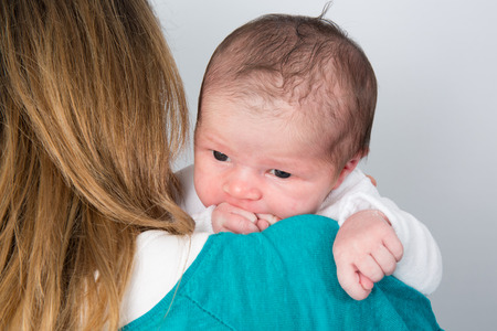 New born  baby with a pacifier in mothers handsの写真素材