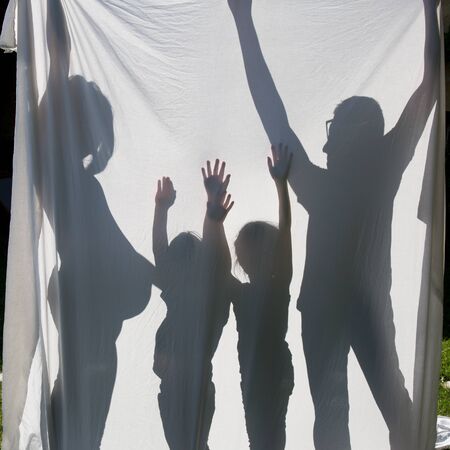 Shadows of a family behind a sheet -Symbol of a familyの写真素材