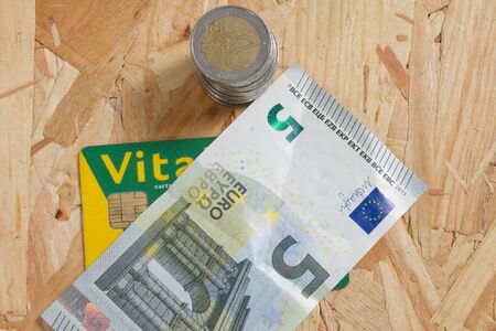 Concept of expensive healthcare with coins,notes and french health cardの写真素材