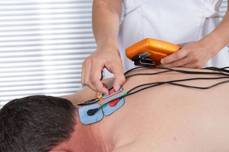 Man with electrostimulator electrodes on his Backの写真素材