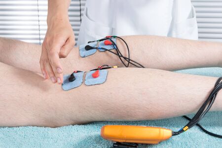 Man with electrostimulator electrodes on his bodyの写真素材