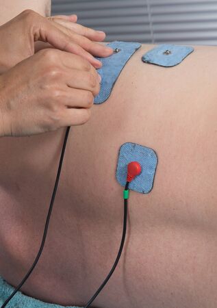 Man with electrostimulator electrodes on his bodyの写真素材