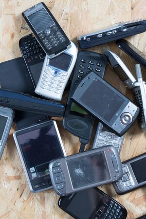 Old and obsolete cellphone on wooden backgroundの写真素材
