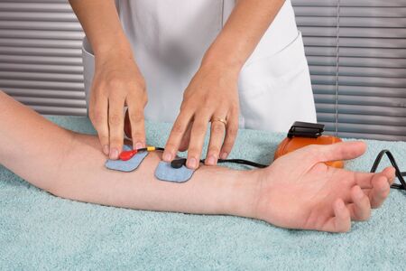 Man is doing massage of electrostimulator Medical procedure.の写真素材