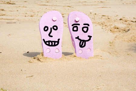 Pink  beach flip flops with  in white sand on sea backgroundの写真素材