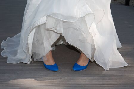 Bride in blue shoes in white dressの写真素材