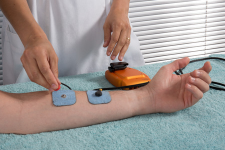 Man is doing massage of electrostimulator Medical procedure.