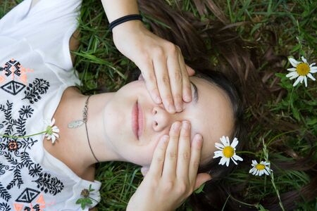 Top view  of a pretty young woman relaxing on a grassの写真素材