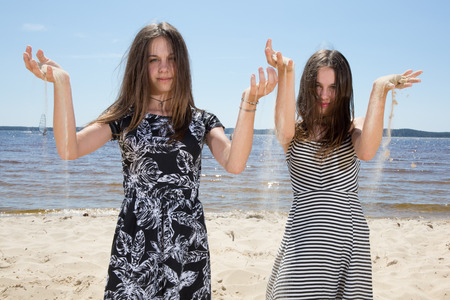Twins, sisters have fun togetaher at the beachの写真素材