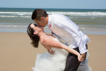 Beautiful wedding couple at the beach with wedding dressの写真素材