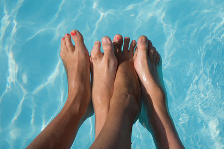 feet of couple near swimming poolの写真素材
