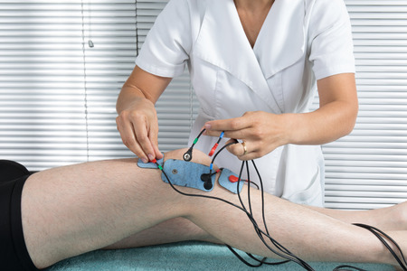 Man is doing massage of electrostimulator Medical procedure.