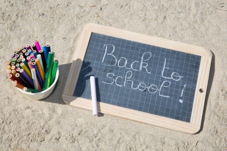 Back to school sign on the beach sand