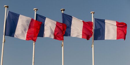 French flags against blue cloudy sky.の写真素材