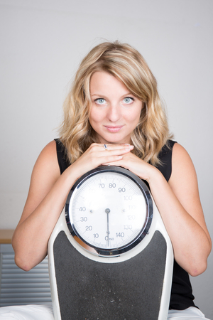 Closeup shot, woman carrying weighing machineの写真素材