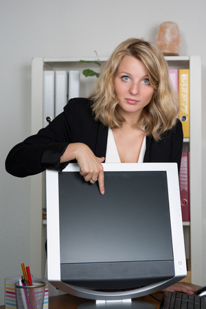 Young blonde business woman presenting screen of computerの写真素材