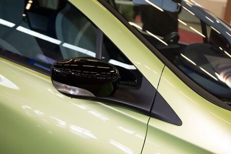 Angle shot of a new green car , and a view mirrorの写真素材