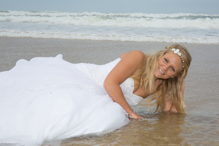 Blond bride woman at the beach at summer timeの写真素材