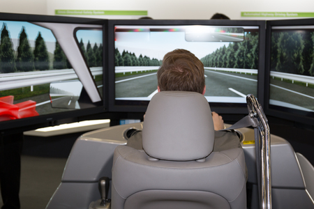 Man in a car simulator in a congress for safetyの写真素材
