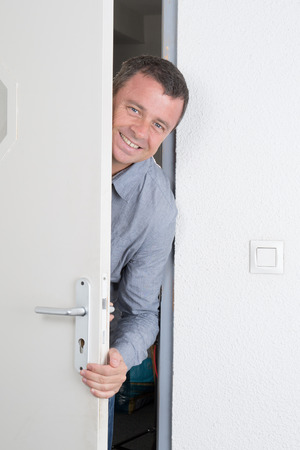 At the door in a bright modern office a man  waiting for someoneの写真素材