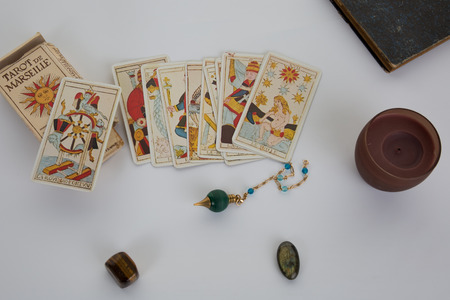 Esoteric table with astrological wheel, magic pendulum, tarots,  healing stones