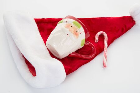 Candy canes, candies and chocolate on Santa hat isolated on whiteの写真素材