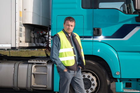 Serious and confident Man standing in front of truckの写真素材