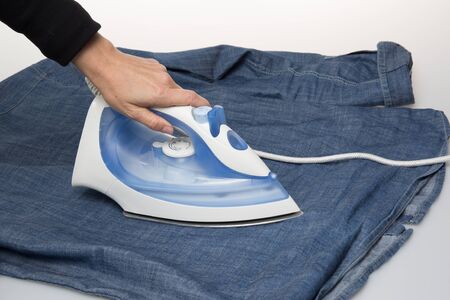 Ironing cloth with steam, closeup isolated on whiteの写真素材