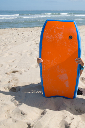 Surfboard is posing on the beach under blue sy and oceanの写真素材