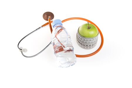 Green wet apple with yellow measuring tape and black stethoscope isolated on white backgroundの写真素材