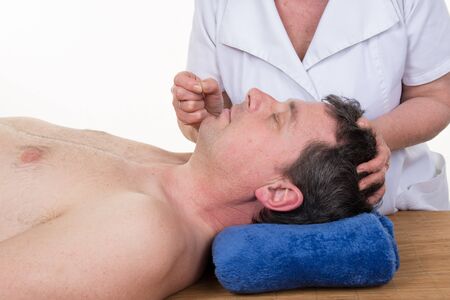Smiling young man in an acupuncture therapy in a Spa centerの写真素材