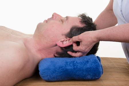 Male beauty - man receiving a facial massageの写真素材