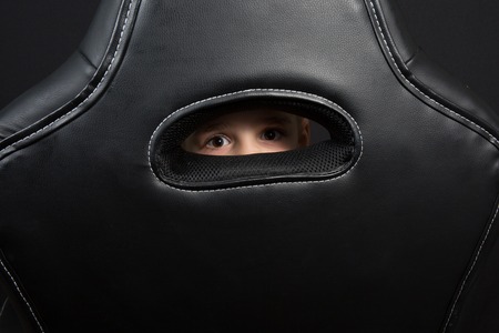 Child looks through something made with leatherの写真素材