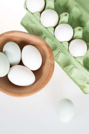 Eggs , white and green, in paper tray isolated on whiteの写真素材