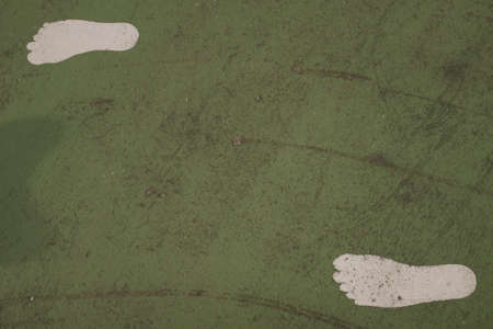 Green dark texture background with bright center spotlight and foot pathの写真素材