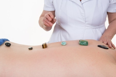 Crystal therapy on the back of the man by therapist of alternative medicine