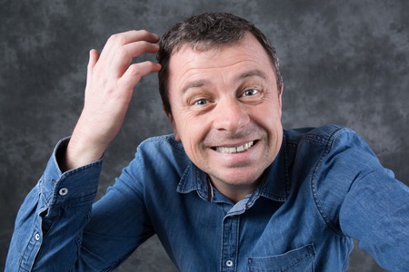 Funny and foolish man isolated on a grey background