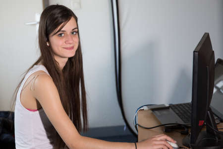 Portrait of an executive professional mature businesswoman sitting on office desk in casual and smiling.の写真素材