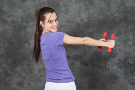 Portrait beautiful young athletic girl on a grey background