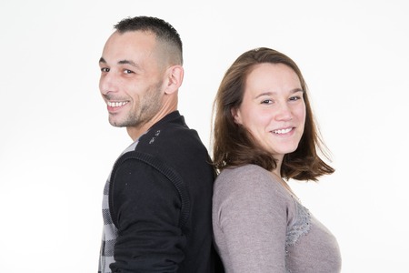 Close up portrait of smiling couple back to back.Isolated on white.の写真素材