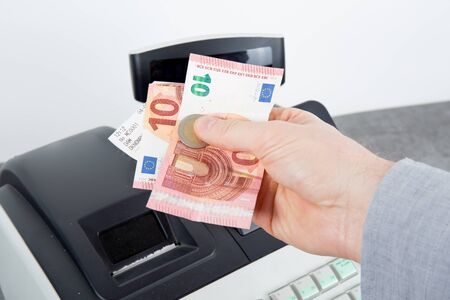 Man at the supermarket giving  Euros to the customer
