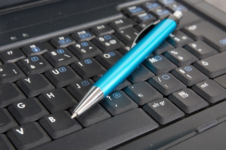 Blue pen and grey laptop. Business concepts.の写真素材