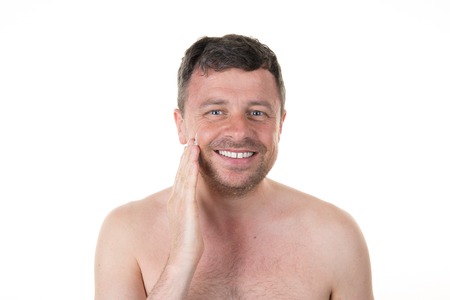 Handsome man in his bathroom shaving in the morning