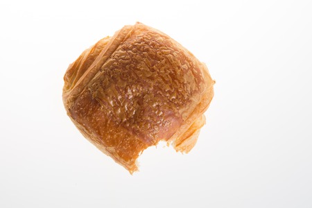 Studio shot of a half eaten fresh pain au chocolatの写真素材