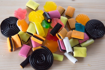 Colorful candies on a wooden table backgroundの写真素材
